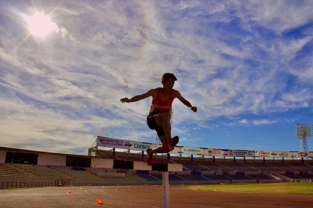 Atleta saltando vallas en estadio de Hermosillo